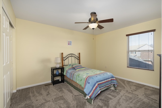 carpeted bedroom featuring a closet, baseboards, and ceiling fan