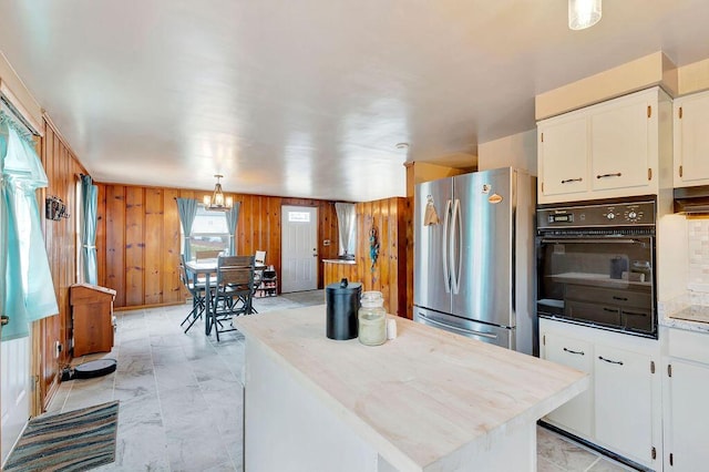 kitchen featuring oven, white cabinets, light countertops, and freestanding refrigerator