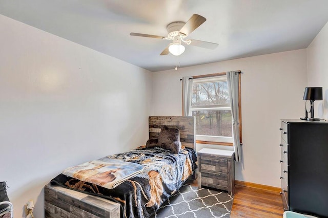 bedroom with wood finished floors, baseboards, and ceiling fan