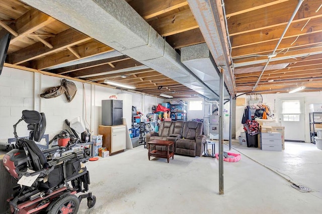 basement featuring plenty of natural light and freestanding refrigerator