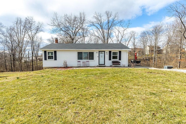 single story home with a chimney, a front yard, and a patio area