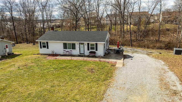 view of front of home with gravel driveway and a front lawn