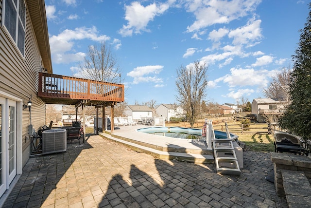 view of patio with central air condition unit, a fenced in pool, a wooden deck, and fence