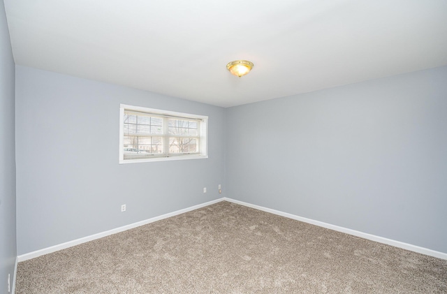 carpeted spare room featuring baseboards