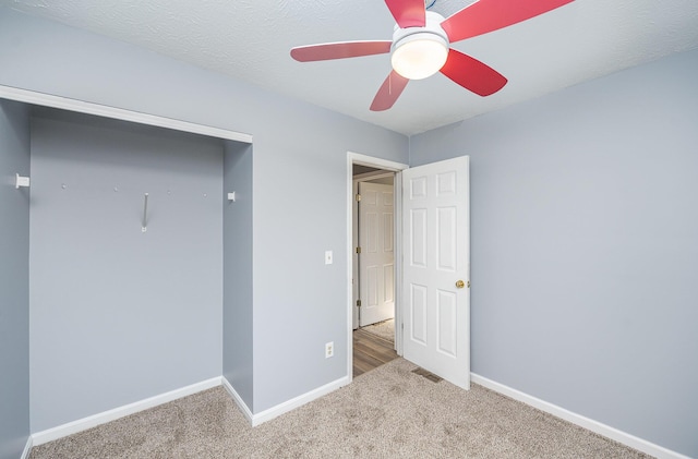 unfurnished bedroom featuring ceiling fan, baseboards, and carpet