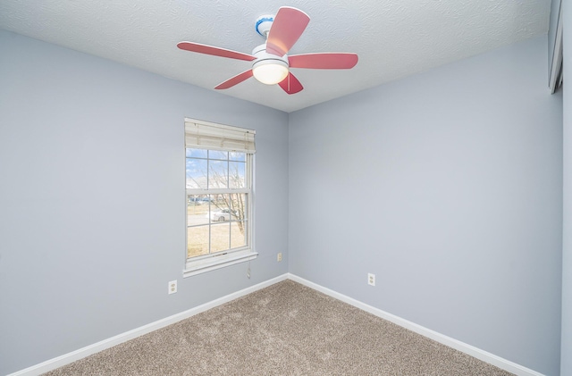 spare room featuring ceiling fan, a textured ceiling, baseboards, and carpet floors