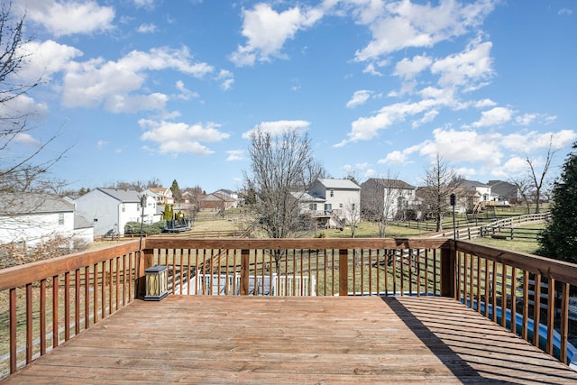 wooden deck with a trampoline, fence, and a residential view