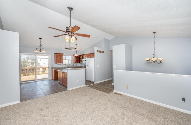 kitchen featuring visible vents, ceiling fan with notable chandelier, open floor plan, dark carpet, and light countertops