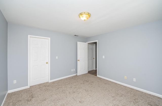 unfurnished bedroom featuring carpet flooring, visible vents, and baseboards