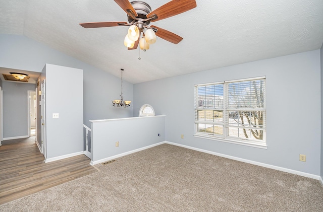 unfurnished room featuring baseboards, a textured ceiling, carpet flooring, and vaulted ceiling