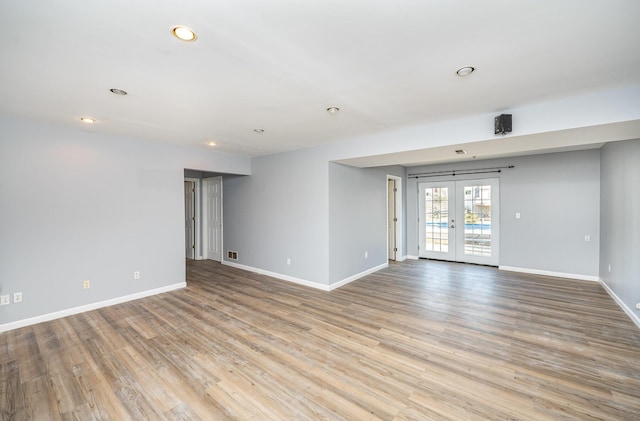 spare room with visible vents, wood finished floors, recessed lighting, french doors, and baseboards