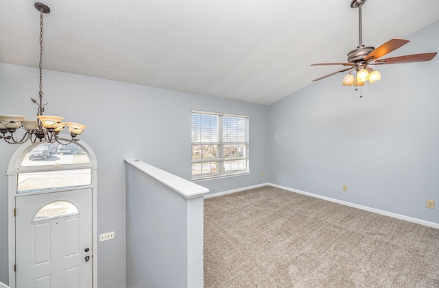 entrance foyer with baseboards, vaulted ceiling, carpet floors, ceiling fan with notable chandelier, and a textured ceiling