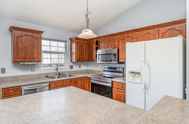 kitchen featuring a sink, hanging light fixtures, vaulted ceiling, stainless steel appliances, and a textured ceiling