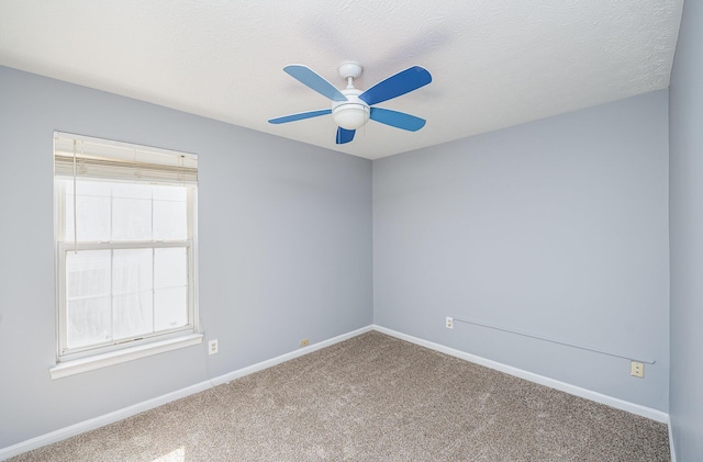 empty room featuring baseboards, carpet, a ceiling fan, and a textured ceiling