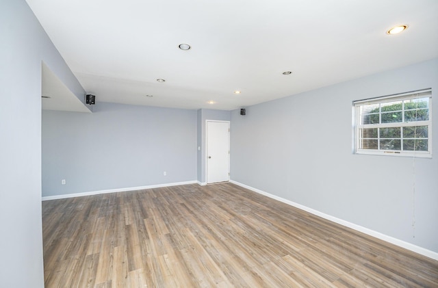 unfurnished room with recessed lighting, wood finished floors, and baseboards