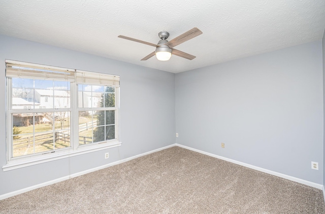 carpeted spare room with baseboards, a textured ceiling, and ceiling fan