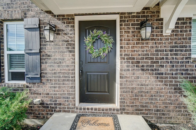 doorway to property with brick siding