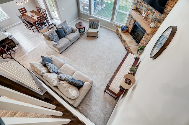 carpeted living room with a glass covered fireplace and baseboards