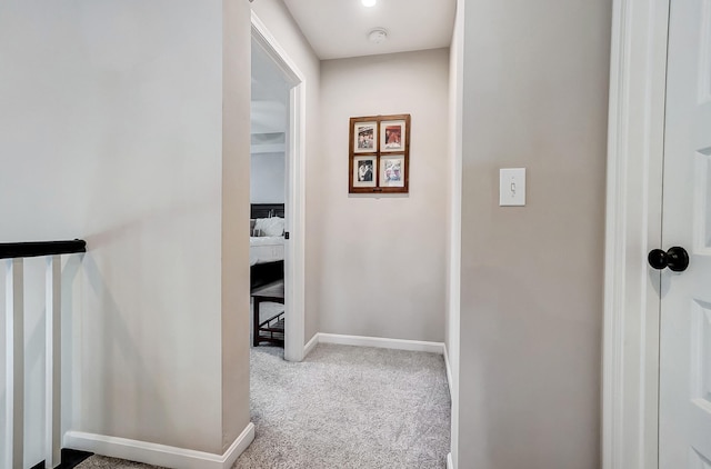 corridor with baseboards and carpet