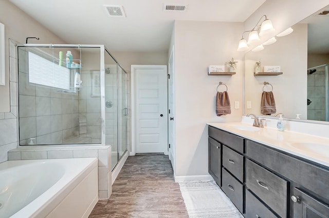 full bath with visible vents, a garden tub, a stall shower, a sink, and double vanity