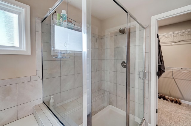 full bathroom with a stall shower and a walk in closet