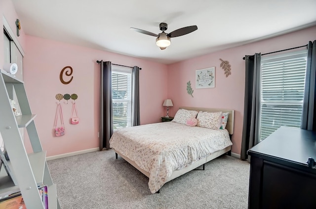 bedroom with light colored carpet, baseboards, and ceiling fan