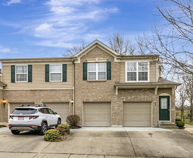 view of front of house with brick siding, driveway, and a garage