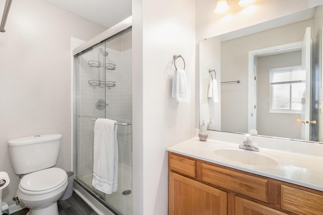 bathroom with vanity, toilet, and a shower stall