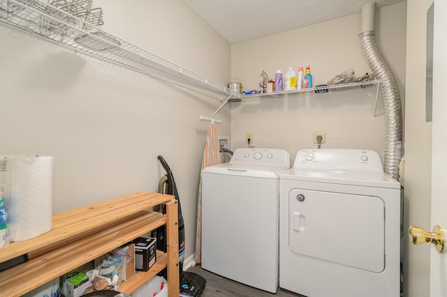 laundry room with laundry area, wood finished floors, independent washer and dryer, and a textured ceiling