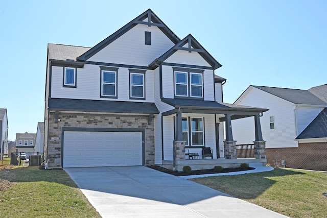 view of front facade featuring stone siding, covered porch, driveway, and a front lawn