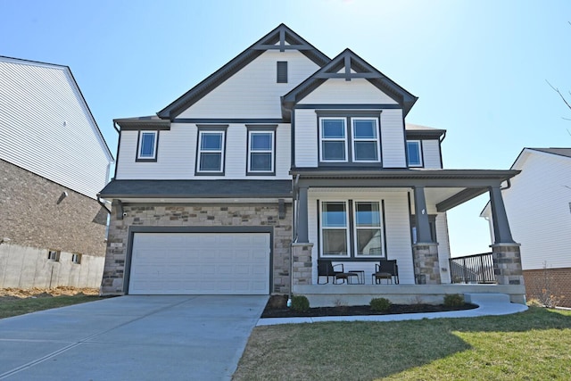 craftsman-style home with a porch, a garage, stone siding, and driveway