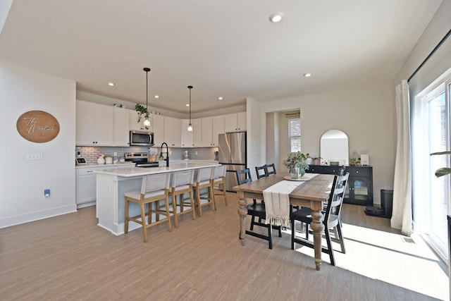 dining area with recessed lighting, baseboards, and light wood-style floors