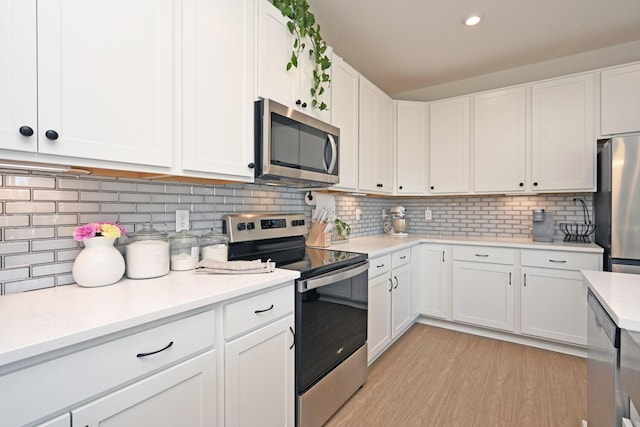 kitchen with appliances with stainless steel finishes, white cabinetry, and light countertops