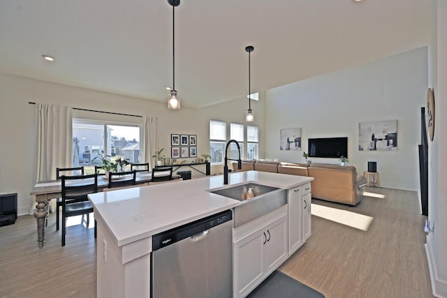 kitchen featuring light wood-style flooring, dishwasher, white cabinetry, and a sink