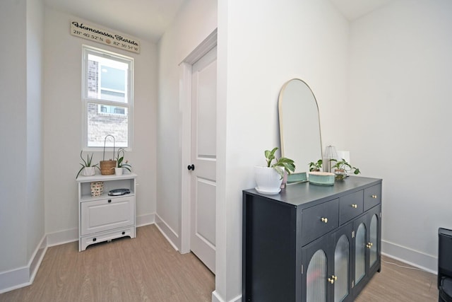 corridor featuring baseboards and light wood-style floors