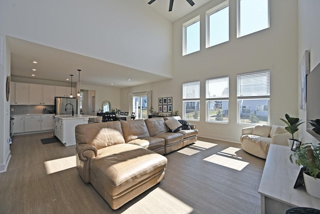 living area with recessed lighting, baseboards, dark wood-type flooring, and ceiling fan