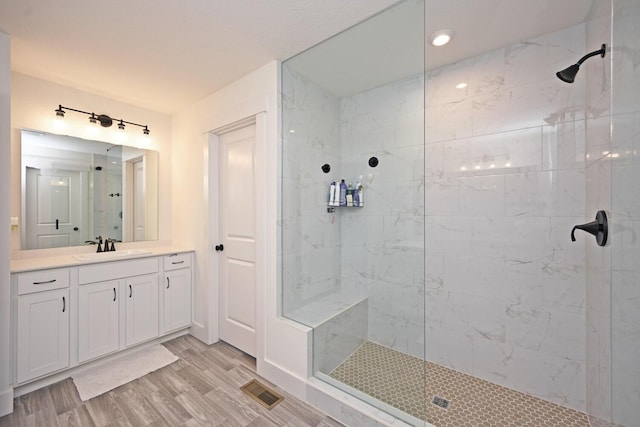 full bath with visible vents, walk in shower, and wood finished floors