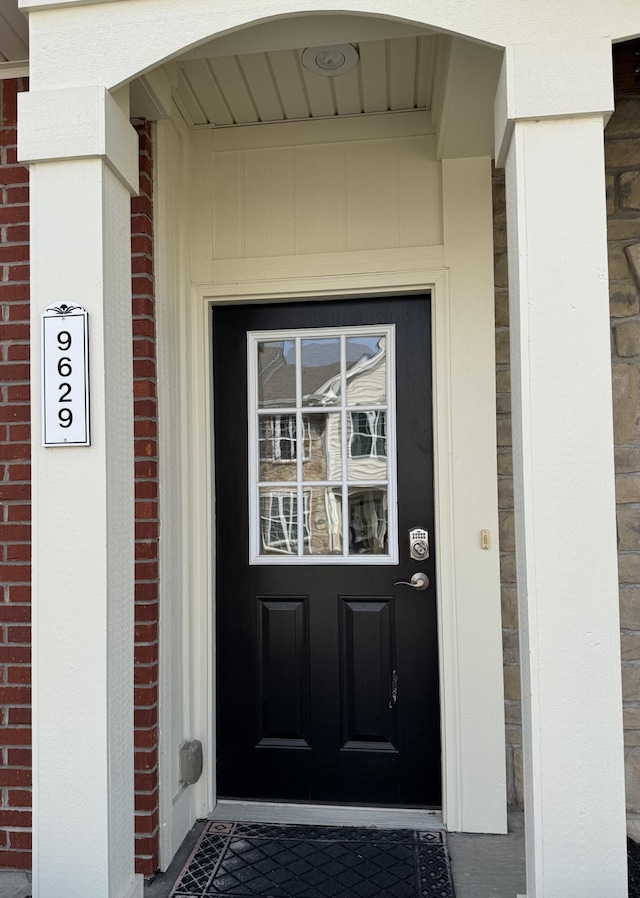 entrance to property featuring brick siding