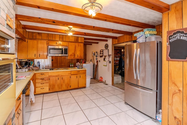 kitchen featuring stainless steel appliances, beam ceiling, wood walls, and light countertops