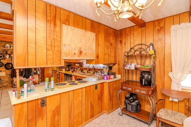 kitchen with brown cabinets, a notable chandelier, a sink, wooden walls, and light countertops