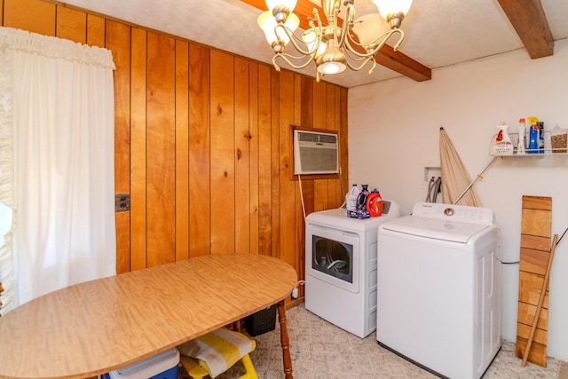 laundry area featuring wooden walls, independent washer and dryer, an inviting chandelier, and a wall unit AC