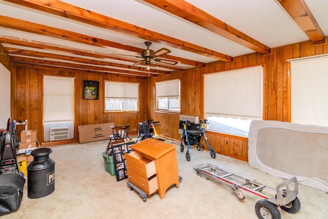 game room featuring beam ceiling, carpet flooring, a ceiling fan, and wood walls