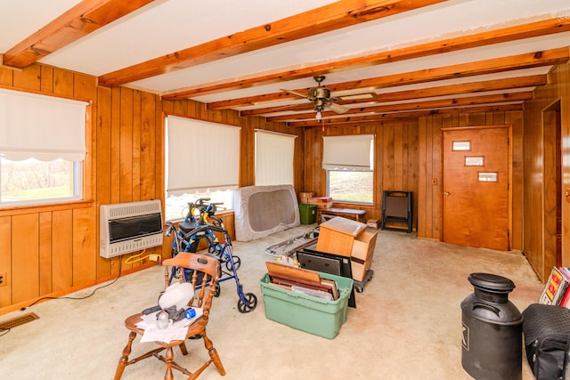 recreation room featuring heating unit, wooden walls, beam ceiling, and a healthy amount of sunlight