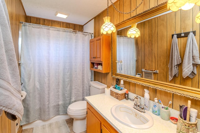 bathroom featuring wood walls, toilet, and vanity