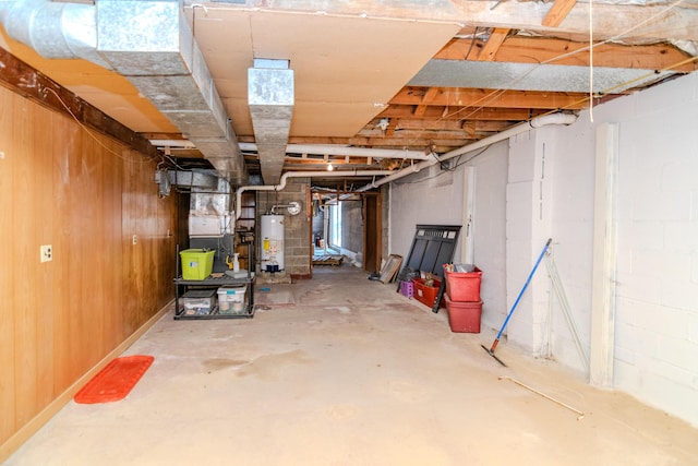 unfinished basement featuring concrete block wall and water heater