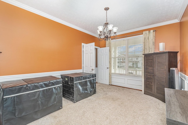 interior space with carpet flooring, a notable chandelier, wainscoting, and ornamental molding