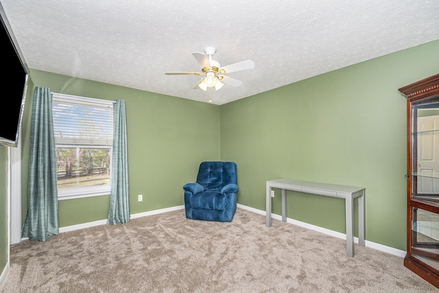 unfurnished room featuring a textured ceiling, carpet, baseboards, and ceiling fan