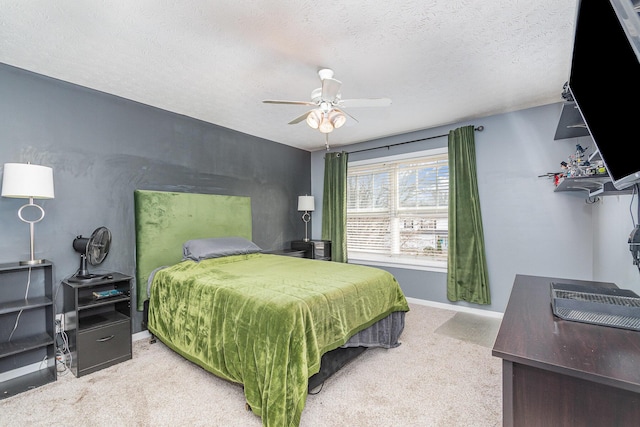 carpeted bedroom with ceiling fan, baseboards, and a textured ceiling