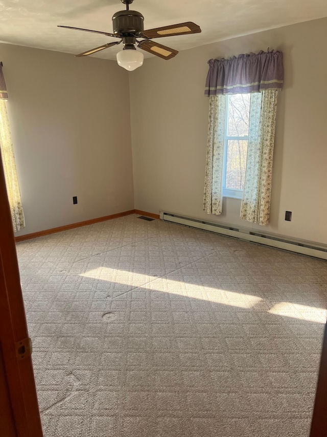 unfurnished room with carpet flooring, a ceiling fan, a baseboard heating unit, and baseboards