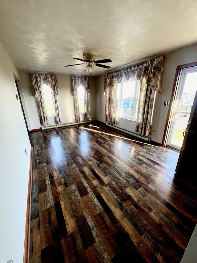 empty room featuring a baseboard radiator, baseboards, ceiling fan, and hardwood / wood-style flooring